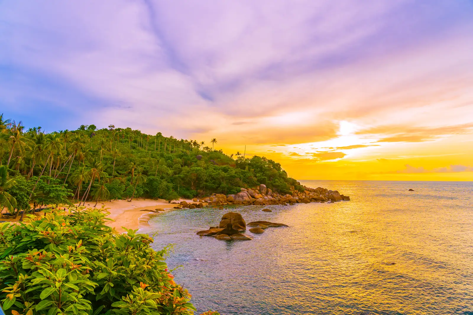 Sunset over a jungle headland and quiet beach on Koh Samui