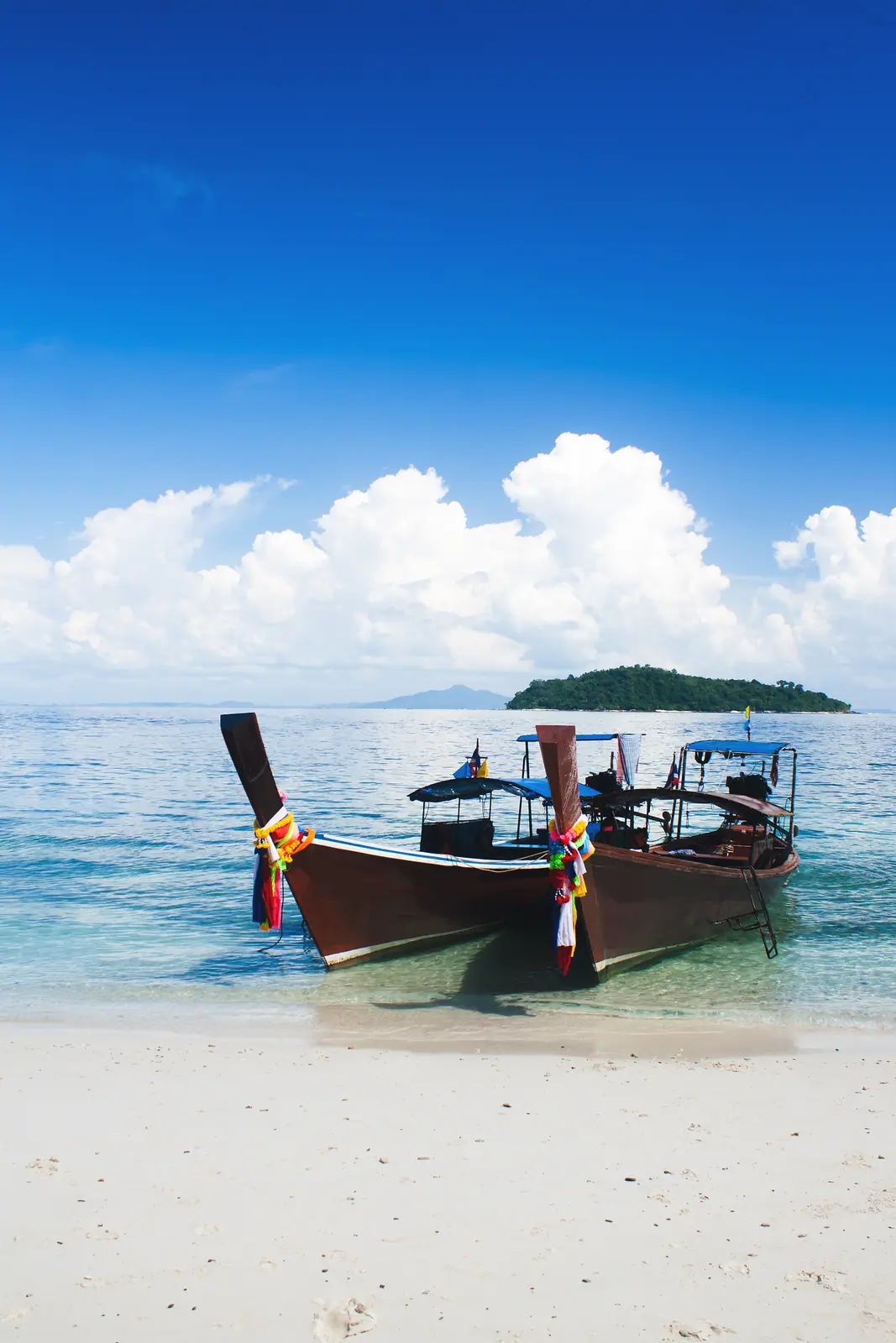 A longtail boat moored in clear turquoise water off Krabi